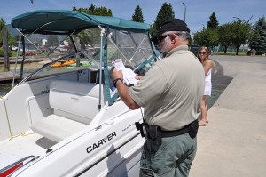 Sheriff's deputy Eric Ahrens conducts a boat inspection. Photo by Cameron Rasmusson
