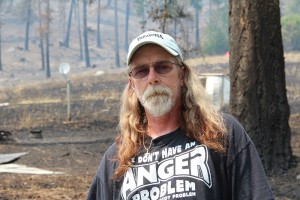 Steve Seier standing before the aftermath of the fire. Photo by Ben Olson.