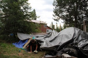 Olive Hess-Mills exits her tent in the morning with the main house in the background. Photo by Ben Olson.