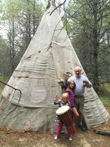 Tim Henney, 84, with his grandchildren outside the hand built teepee. Photo courtesy Justin Henney.