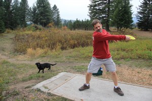 Damien Gooding prepares to tee off on hole #1 at Baldy Park with his dog Lily. Photo by Ben Olson.