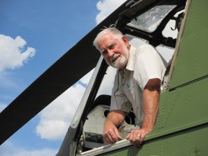Vietnam veteran Bill Collier poses in his derelict H-34 helicopter, the same model he flew in the war – and the subject of his new book. Photo by Carla Keefer.