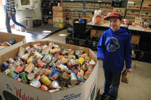 Jordan Tyler, a 3rd grader at Northside School, helps his father volunteer at the Food Band Wednesday. Photo by Ben Olson