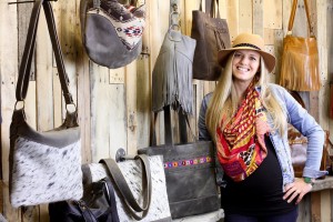 Kimberly Stoddard stands before her creations at 14x Bags in the Cedar Street Bridge Market. Photo by Howard Stoddard.