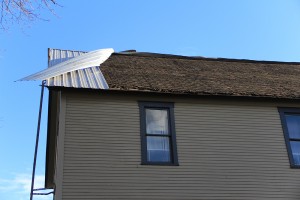 A piece of sheet metal hangs off the roof of an apartment building at Pine and Forest the morning after a wind storm left over 150,000 people in the Inland NW without power. Photo by Ben Olson