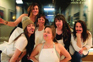 The group of Syringa Salon hairdressers and Cadie show off their acrylic mustaches. Photo by Ben Olson.