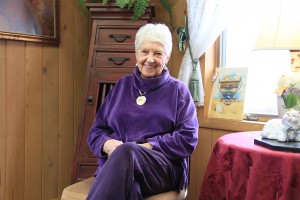 Lois Miller sitting in the parlor room at The Cottage Thrift Store. Photo by Ben Olson.