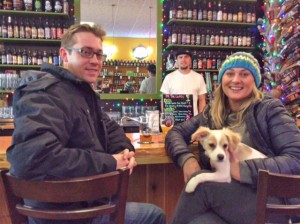 Customers John Grubbs and Lindsay Nance pose with their new pooch Reggie, while Jake Hagadone looks on from behind the bar.