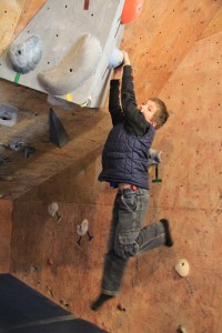 Micah Stoneham, 8, hangs from a wall at Sandpoint Rock Gym. Photo by Ben Olson.