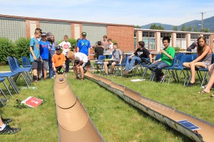 Nathan Ford (crouching behind car) launches his solar car during Tuesday’s competition at SMS. Photo by Ben Olson.