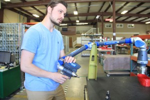 Tamarack employee Eric Schneider takes a 3D scan of a faro arm at the Ontario Street facility. Photo by Ben Olson.