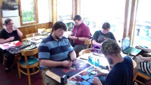 Brenton Watson (in stripes) begins a Magic game, while new decks and fantasy art are created around him. Photos by Jodi Rawson.