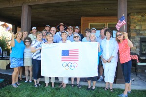 Karen Burnett, middle behind banner with white hat, stands with friends and neighbors in front of a banner they all plan to sign. Karen will hand deliver the banner to Rio in support of the men’s freestyle wrestling team. Photo by Ben Olson.
