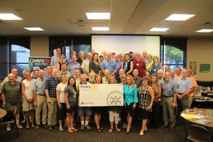 Rotarians, guests and sponsors proudly show off the $50k check donated to LPOSD. Photo by Ben Olson