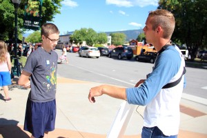 Chris Hutto, right, preaches to a Sandpoint youth at the Farmers’ Market in Sandpoint. Photo by Ben Olson.