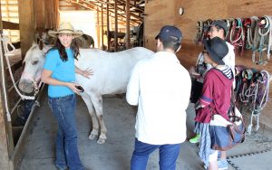 Wrangler Danielle Otis, left, shows exchange students around Western Pleasure Guest Ranch. Photo by Landon Otis.