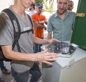 Aubrey Falconer, right, looks at a miniature version of the Solar Roadway panel at Saturday’s unveiling at Jeff Jones Town Square. Photo by Cameron Barnes.