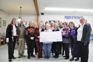 Walmart employees stand with a group of Sandpoint seniors after handing SASi a check for $28,750 on Thursday. Photo by Ben Olson.