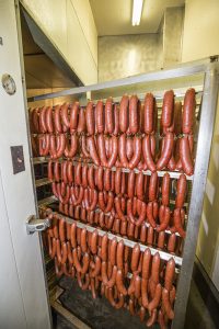 “Smokies” are cooled and prepared for packaging after a long cook in the roaster at Wood’s Meat Processing. Photo by Cameron Barnes.