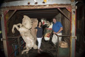 Reno and Clay Hutchison stand amidst the hand-carved horses in one of two vintage trailers containing the 1920 “Carousel of Smiles” to be unloaded Dec. 3. Courtesy photo.
