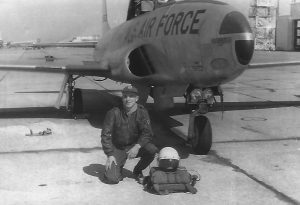 Jim Ramsey kneels before his T-33 jet trainer in this photograph taken in 1957 at Bryan A.F.B, Texas. Courtesy photo.