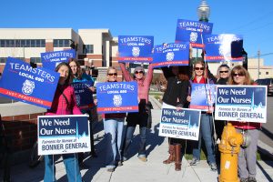 A group of supporters hold signs in front of the BGH Health Services Building in Sandpoint on Tuesday. Photo by Ben Olson.