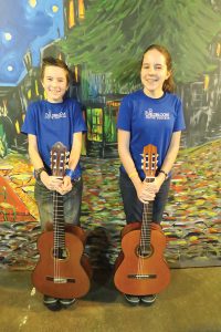 Israel Yandt, left, and Isabella Yandt, right, pose with their guitars after a lesson. Photo by Ben Olson.