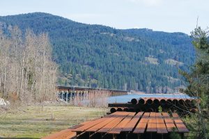 A pile of rusty equipment sits at Dog Beach with the train bridge in the background. Photo by Ben Olson.