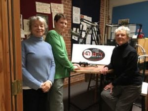 Tom Carty, center, stands with KRFY’s Suzy Prez, left and interviewee Sue Vogelsinger, who worked for JFK in the White House. Photo courtesy KRFY.