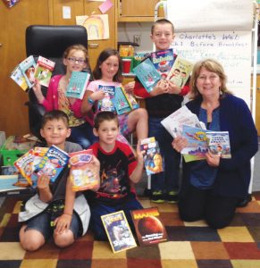 Ms. Davis and her second grade students at Farmin Stidwell excitedly show off their own monthly Book Trust books. Front row from left to right: Toby Walker, Daniel Rodrigues, Ms. Davis, Back row: Jade Thompson, Hope Kelly, Jacob Alexander. Photo by Jim Ramsey.