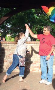 Jessica Chilcott high fives Jeff Bohnhof at the candlelit vigil for the Pulse Nightclub shooting victims in June 2016. Photo by Donna Brundage.