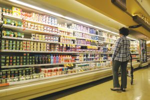 A shopper navigates the dairy section inside Sandpoint’s Safeway grocery store. Photo by Ben Olson.